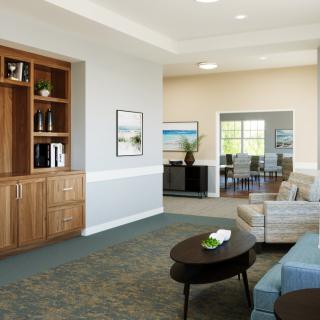 A modern living room with comfortable sofas, a wooden bookshelf, and a view into the dining area.