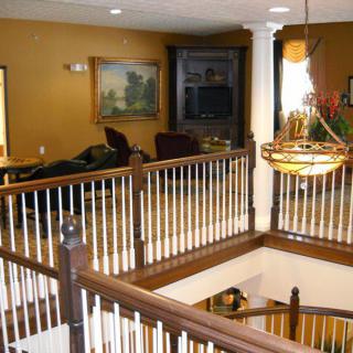 A cozy interior featuring a wooden staircase with a view into a warmly decorated living area.