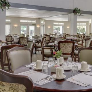 An elegant dining area with neatly set tables and chairs, ready for guests.