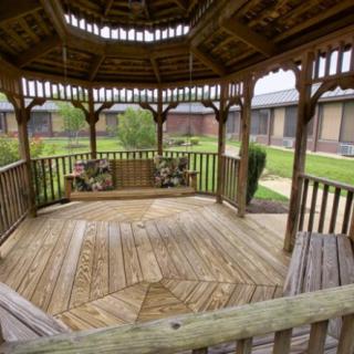 A wooden gazebo set in a garden courtyard, offering a peaceful outdoor retreat.