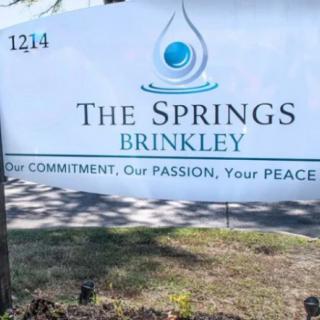 A sign for The Springs at Brinkley, featuring their slogan 'Our Commitment, Our Passion, Your Peace.'