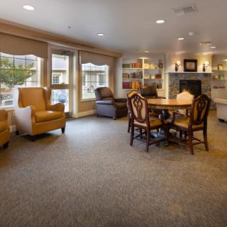A cozy living room with seating area, a round table, and a fireplace.