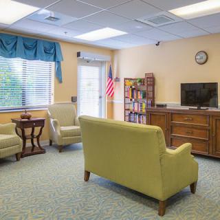 A cozy living room with comfortable seating, a TV, and a bookshelf.