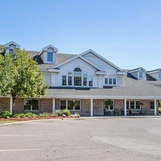 A suburban residential building with a landscaped front and clear blue sky.