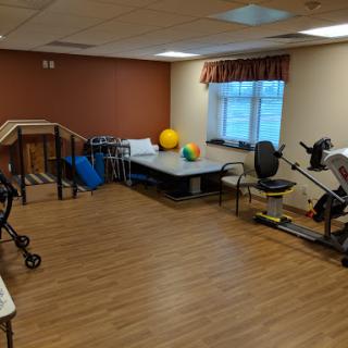 A spacious rehabilitation and exercise room equipped with various fitness tools for physical therapy.