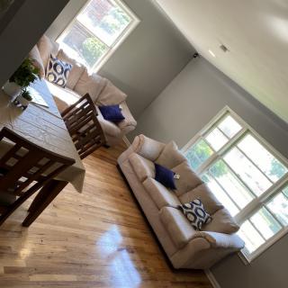 A bright and airy living room with comfortable sofas and a dining table.