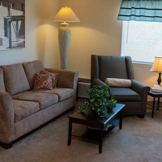 A cozy living room with a sofa, armchair, and coffee table.