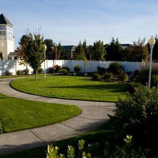 A beautifully landscaped park with a winding pathway and lush greenery.