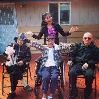 A joyful outdoor gathering with family members seated and smiling on a sunny day.