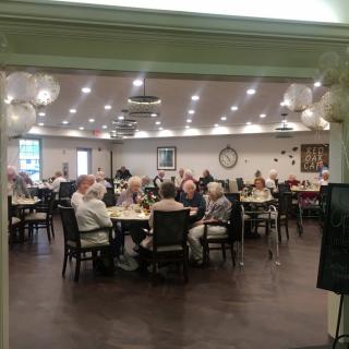 A group of seniors gathered in a dining room at a community center.