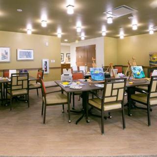 A well-lit art room with tables and chairs arranged for creative activities.