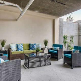 A modern outdoor patio with rattan furniture and colorful cushions.