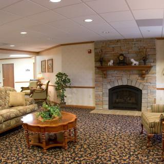 A cozy living room with a fireplace, sofa, and coffee table, featuring elegant decor.