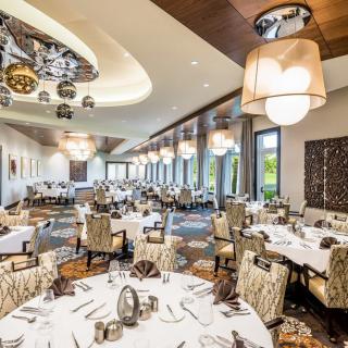 An elegantly designed restaurant dining area with neatly arranged tables and stylish lighting.