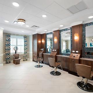 A modern hair salon featuring stylish barber chairs, well-lit mirrors, and contemporary decor.