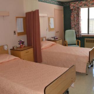 A hospital room with two beds separated by a curtain.
