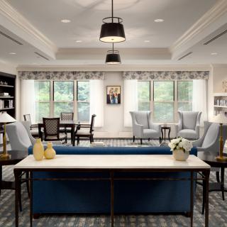 A stylish and well-lit living room featuring comfortable seating and a large window view.
