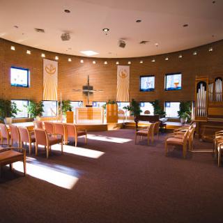 A serene interior view of a modern chapel, featuring comfortable seating and gentle lighting.
