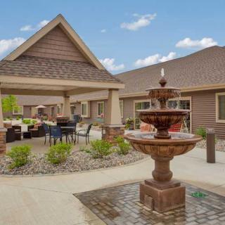 A serene outdoor area featuring a fountain and covered patio with seating.