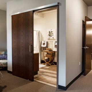 A home office with a sliding door partially open, revealing a cozy workspace.