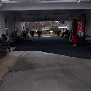 A view of a garage pathway with seating and a vending machine.