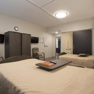 A view of a hospital room with two beds and medical equipment.
