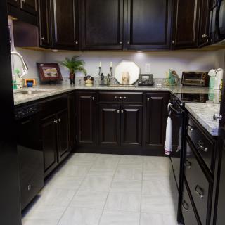 A modern kitchen featuring dark wood cabinets and sleek appliances.