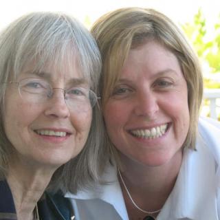 Two women smiling together outdoors.