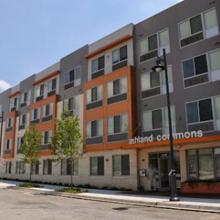 A modern apartment building featuring a mix of colors and designs, set in an urban environment.