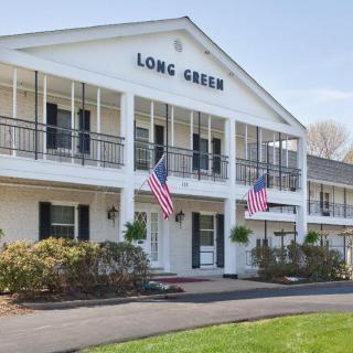 A white building with balconies, displaying American flags and a sign that reads 'Long Green'.
