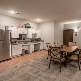 A modern kitchen and dining area with stainless steel appliances and a wooden dining table.
