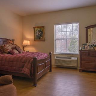 A cozy bedroom with wooden furniture and warm lighting.