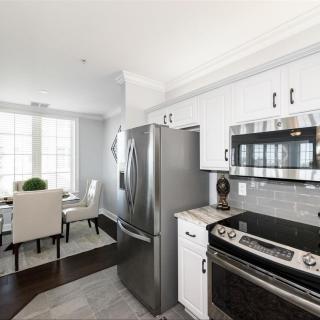 A modern kitchen with stainless steel appliances and an adjoining dining area.