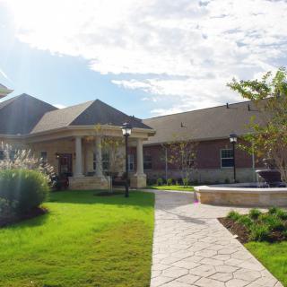 A modern house with a well-manicured lawn and pathway under a sunny sky.