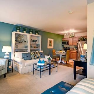 Cozy living room with a connected dining area and kitchen, featuring comfortable furniture and stylish decor.