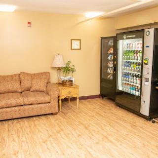 A cozy relaxation area featuring a sofa and a vending machine stocked with drinks.