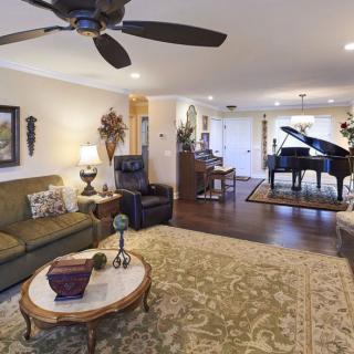 A spacious living room featuring elegant furniture and a grand piano.