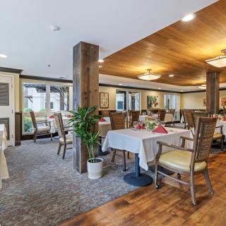 A cozy and elegantly decorated dining area with neatly arranged tables and chairs.