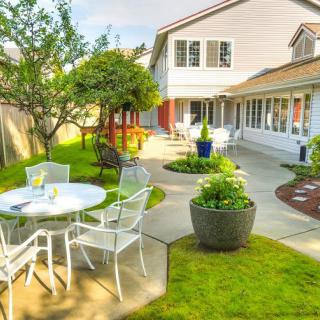 A sunny backyard patio with outdoor furniture and a well-maintained garden.