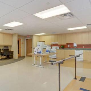 A rehabilitation room equipped with parallel bars and exercise equipment.