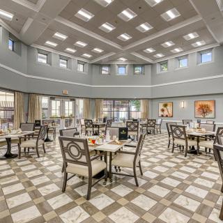 A spacious and elegant dining room with neatly arranged tables and chairs.