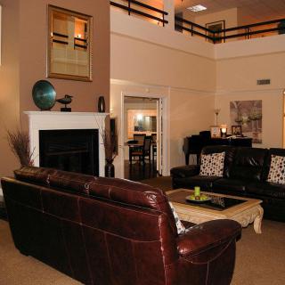 A cozy living room with leather couches and a fireplace, accented by a decorative globe.