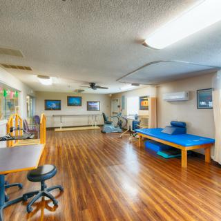 A spacious rehabilitation center equipped with exercise and therapy equipment.