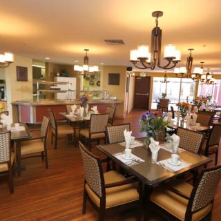 A beautifully arranged dining room with elegant tables and chairs, warm lighting, and tasteful decor.