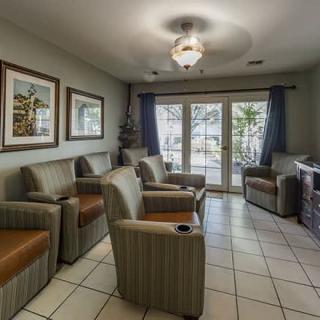 A cozy waiting room with comfortable chairs and artwork on the walls.
