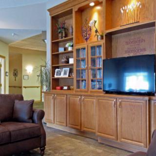 A cozy living room featuring a large wooden bookshelf with a television and comfortable seating.