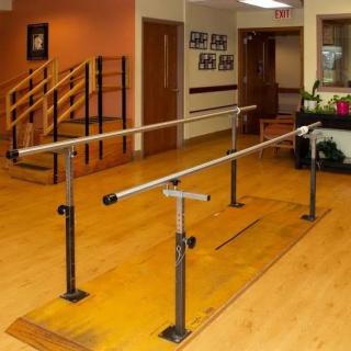 A physical therapy clinic featuring parallel bars used for rehabilitation exercises.
