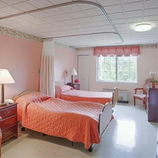 A cozy bedroom with two beds and pink decor.