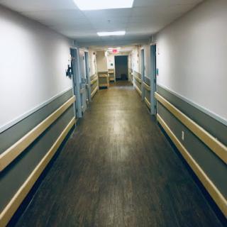 A long, well-lit hallway with doors on either side.