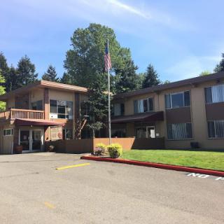 A well-maintained hotel with a welcoming exterior and a lush green space.